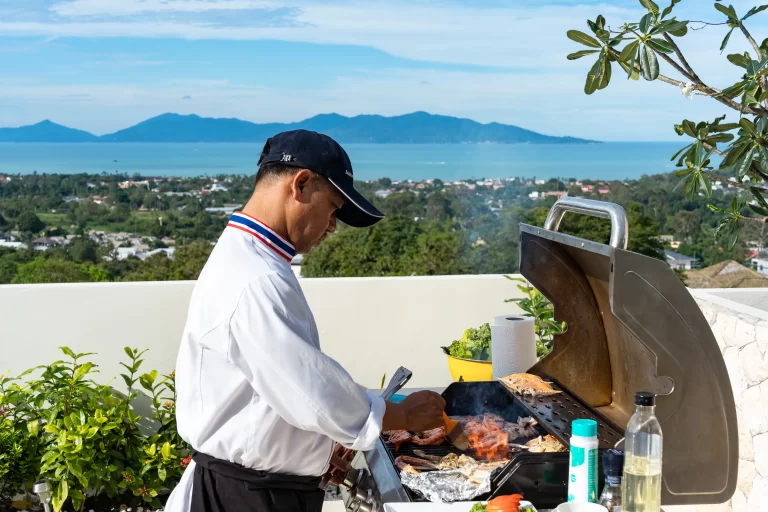 chef preparing bbq in the backdrop of stunning seaview